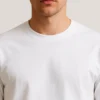 Detalle de cuello redondo y puño elástico de remera mangas largas blanca