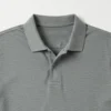 Detalle de cuello y tejido piqué de chomba gris
